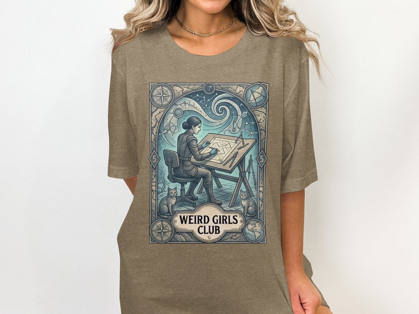 Woman in t-shirt, seated at drafting table with cats, "Weird Girls Club" text.