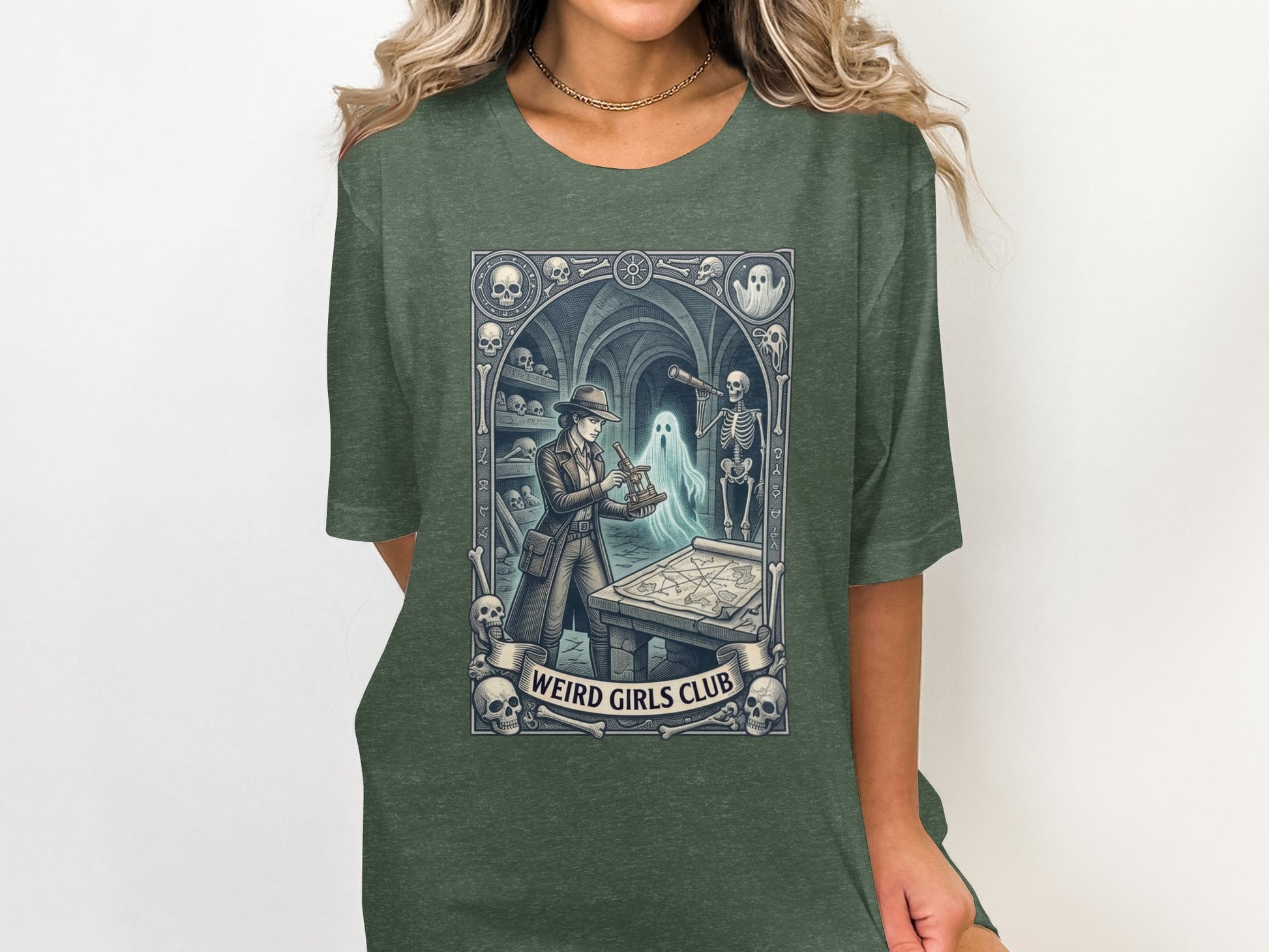 T-shirt graphic featuring a woman and skeleton exploring a map, "Weird Girls Club" text.