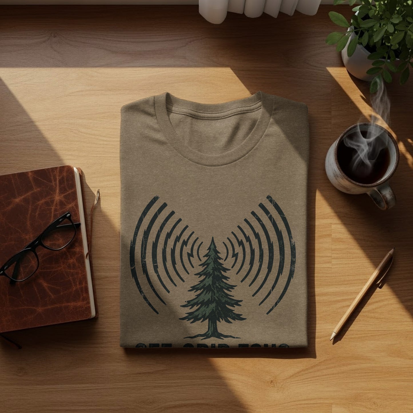 Off-Grid Radio Adventures | Vintage Outdoor Apparel: T-shirt with pine tree and radio wave graphic, coffee, and notebook.