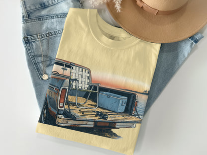 Cream t-shirt with vintage pickup truck graphic and fishing gear in bed.