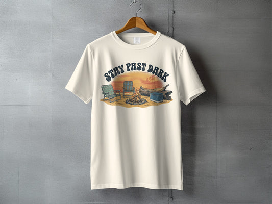 Cream t-shirt with "STAY PAST DARK" text over campfire, chairs, and log graphic.