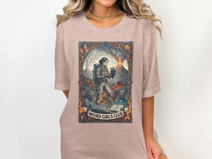 Graphic tee with volcano, woman, grapes, and text "WEIRD GIRLS CLUB".