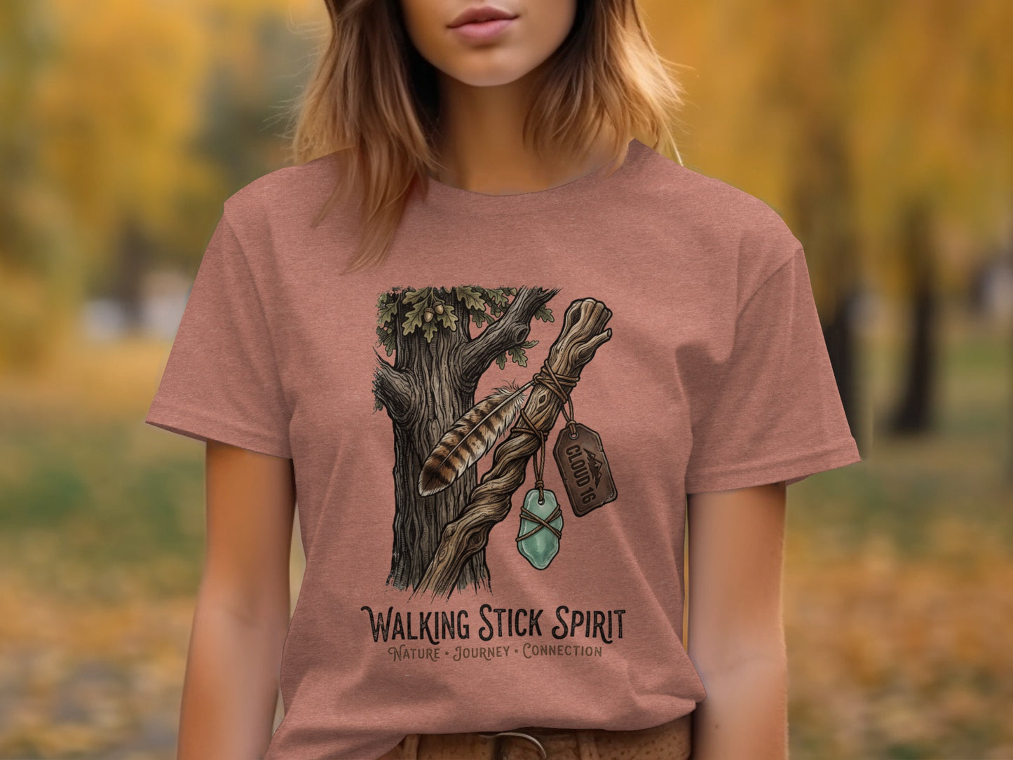 Heritage Walking Stick Spirit: Journey Nomad Tee: T-shirt graphic: wooden staff with feather, crystal, and tag labeled "CLOUD 10".