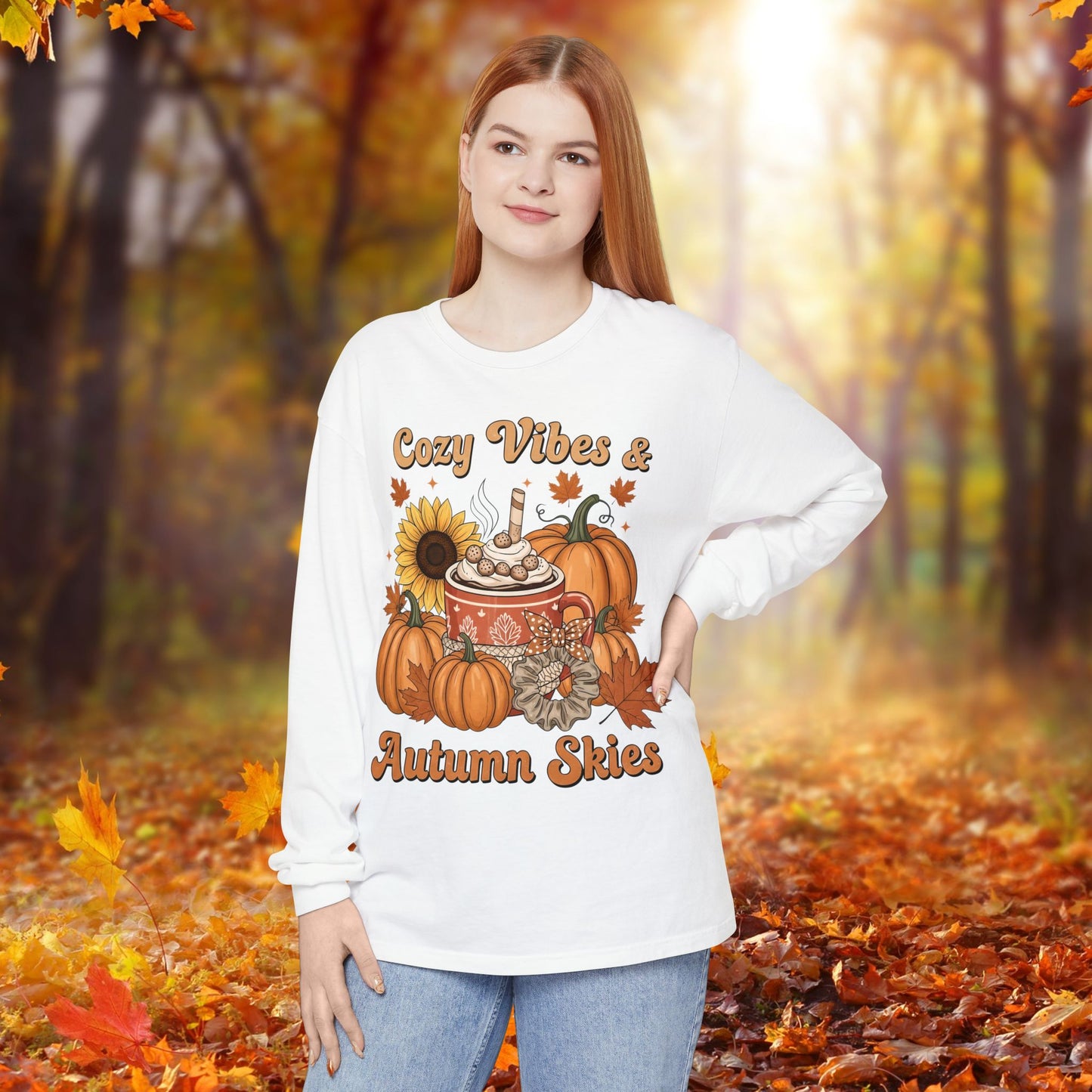 Person wearing a white sweatshirt with autumn-themed design in an autumn forest setting
