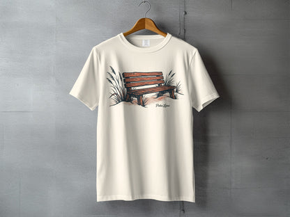 Cream t-shirt with illustration of a wooden bench and tall grass.