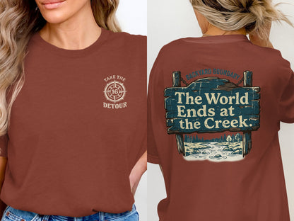 T-shirt with compass graphic and text "Take the Detour" on front, and "The World Ends at the Creek" sign on back.