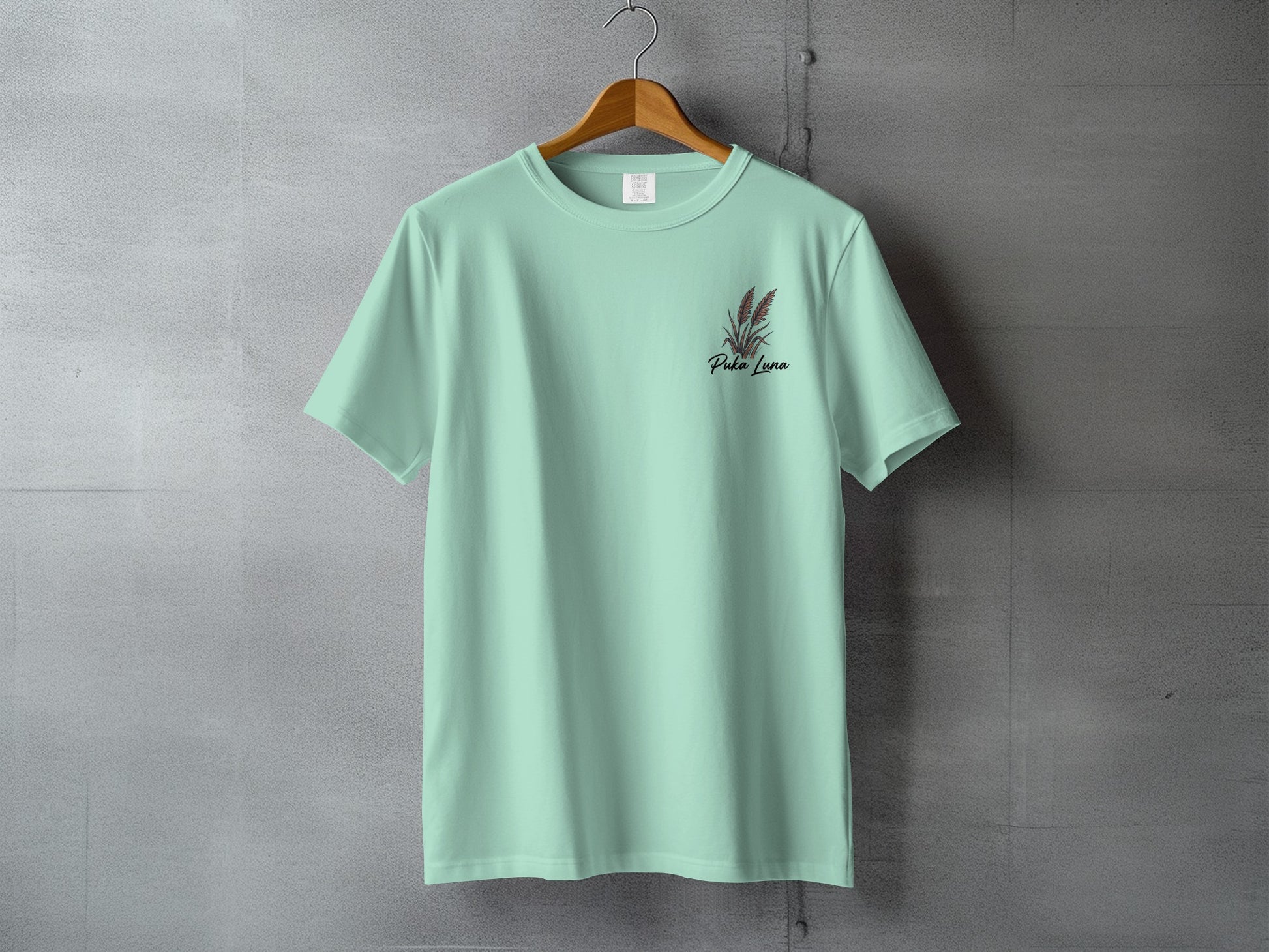 Mint green t-shirt with "Perla Luna" and floral design on left chest.