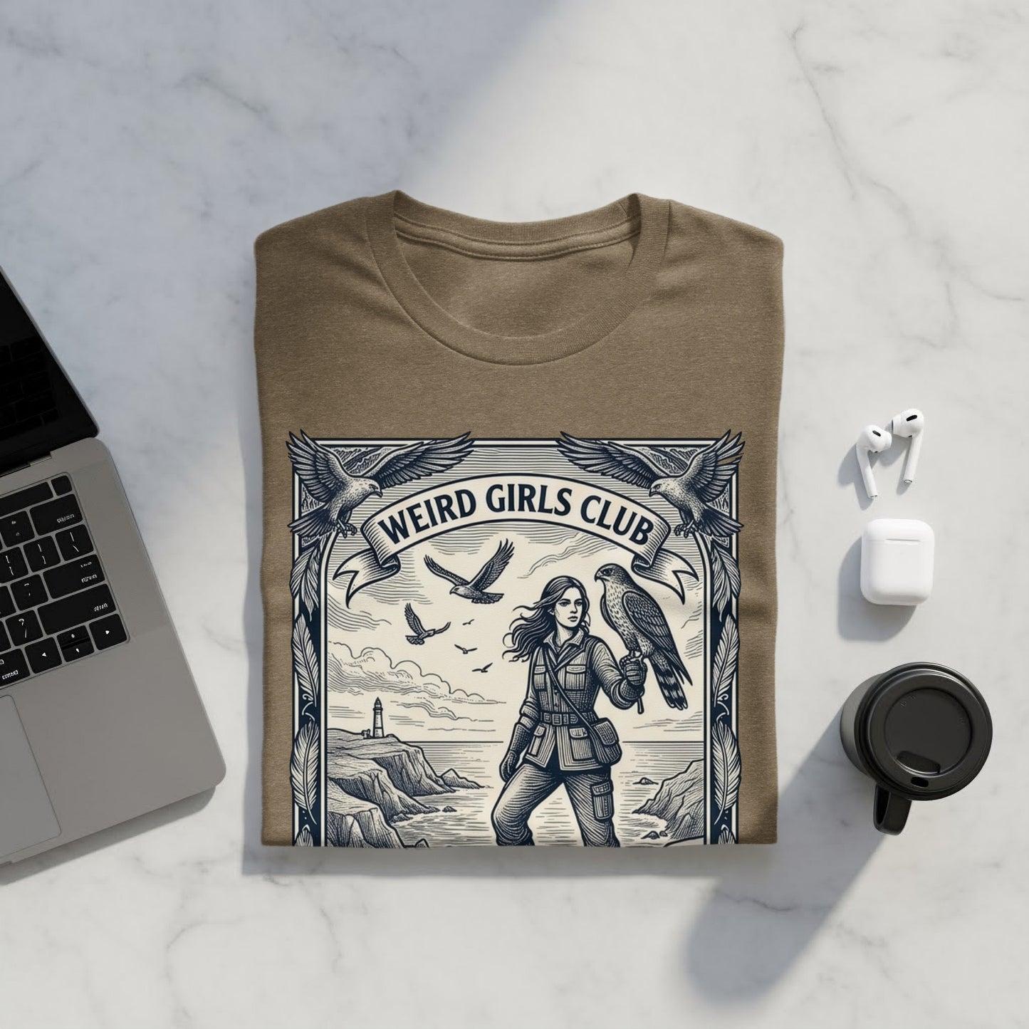 T-shirt with "Weird Girls Club" text and a woman with a hawk on a cliffside.