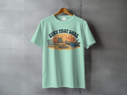 Mint t-shirt with "STAY PAST DARK" text over campfire scene with chairs.