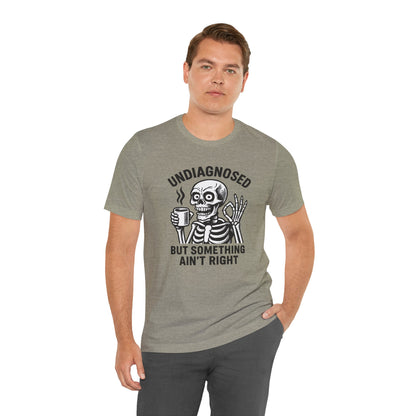 Man wearing a gray t-shirt with a skeleton graphic and text on a white background