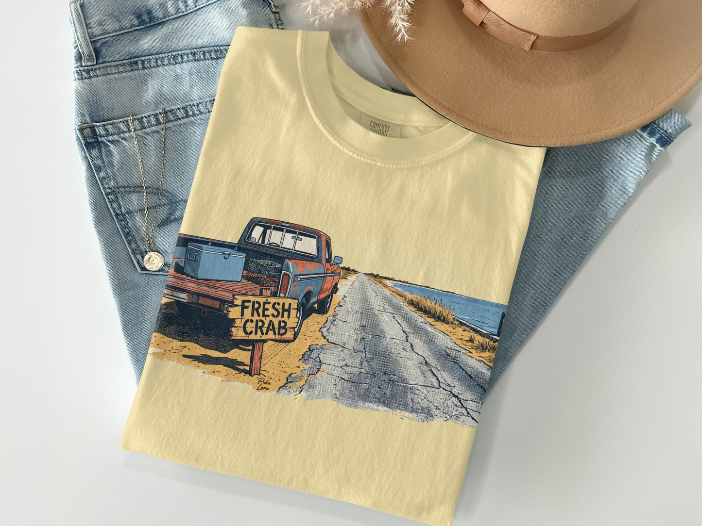 Cream t-shirt with vintage truck, "FRESH CRAB" sign, and road scene graphic.