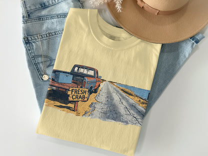 Cream t-shirt with vintage truck, "FRESH CRAB" sign, and road scene graphic.
