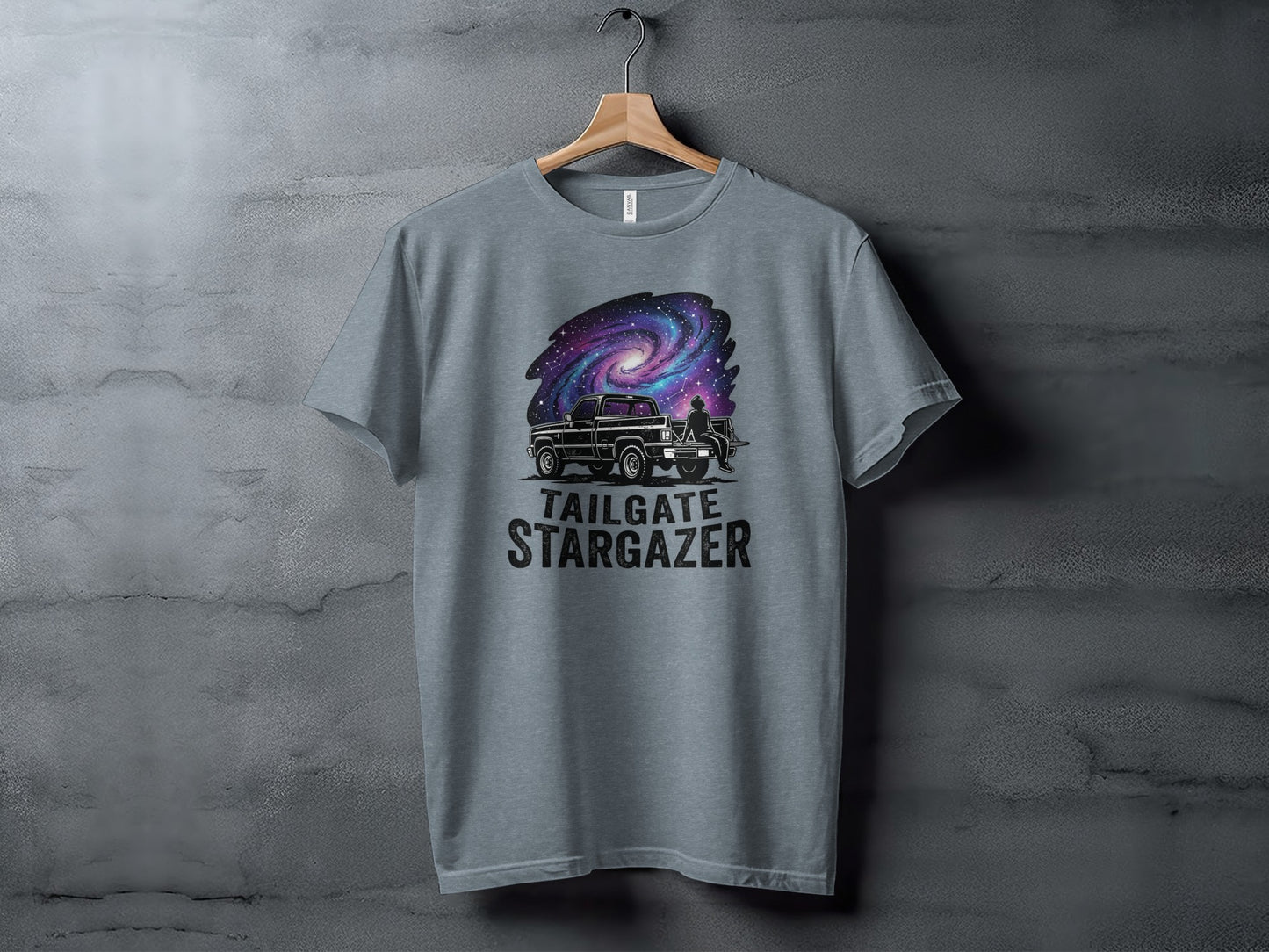 Heritage Cosmic Tailgate Stargazer Nomad Tee: T-shirt graphic of a truck under a galaxy with "Tailgate Stargazer" text.