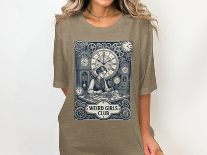 T-shirt graphic of a woman assembling gears and clocks, with "WEIRD GIRLS CLUB" text.