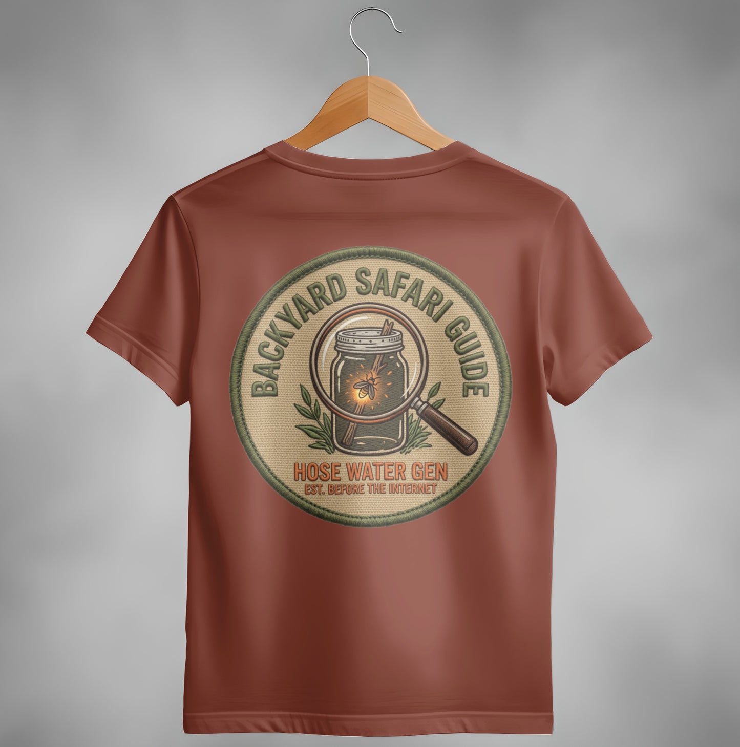 Backyard Safari Guide hose water gen embroidered patch on brown t-shirt.