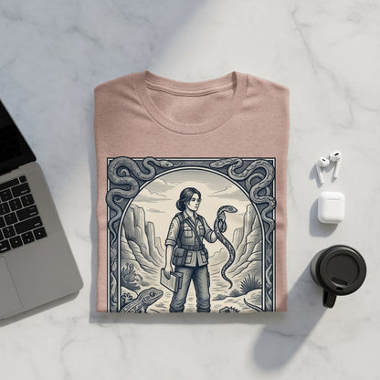 Woman holding snake in desert landscape, framed design on a tan t-shirt.