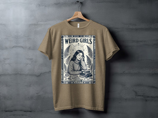 T-shirt featuring "Weird Girls Club" text and woman reading surrounded by foliage.