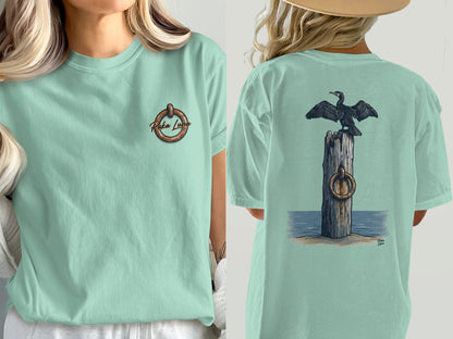 Mint green t-shirt with a cormorant on a post and "Puka Luna" logo.