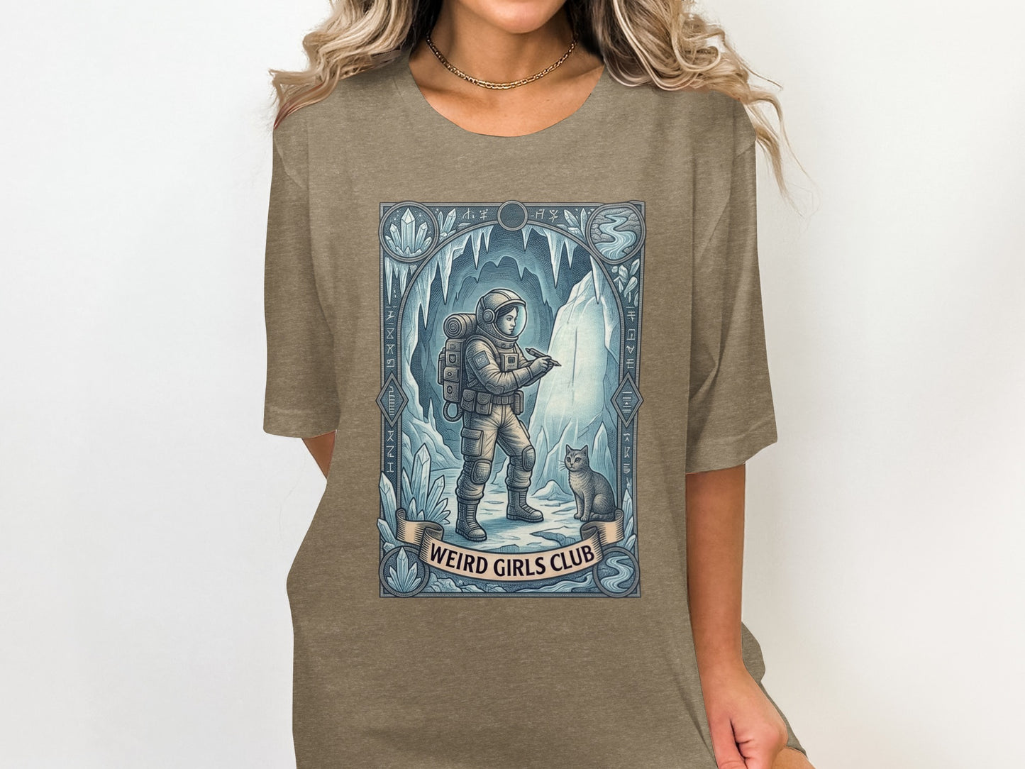 Astronaut and cat in icy cave, "Weird Girls Club" text.