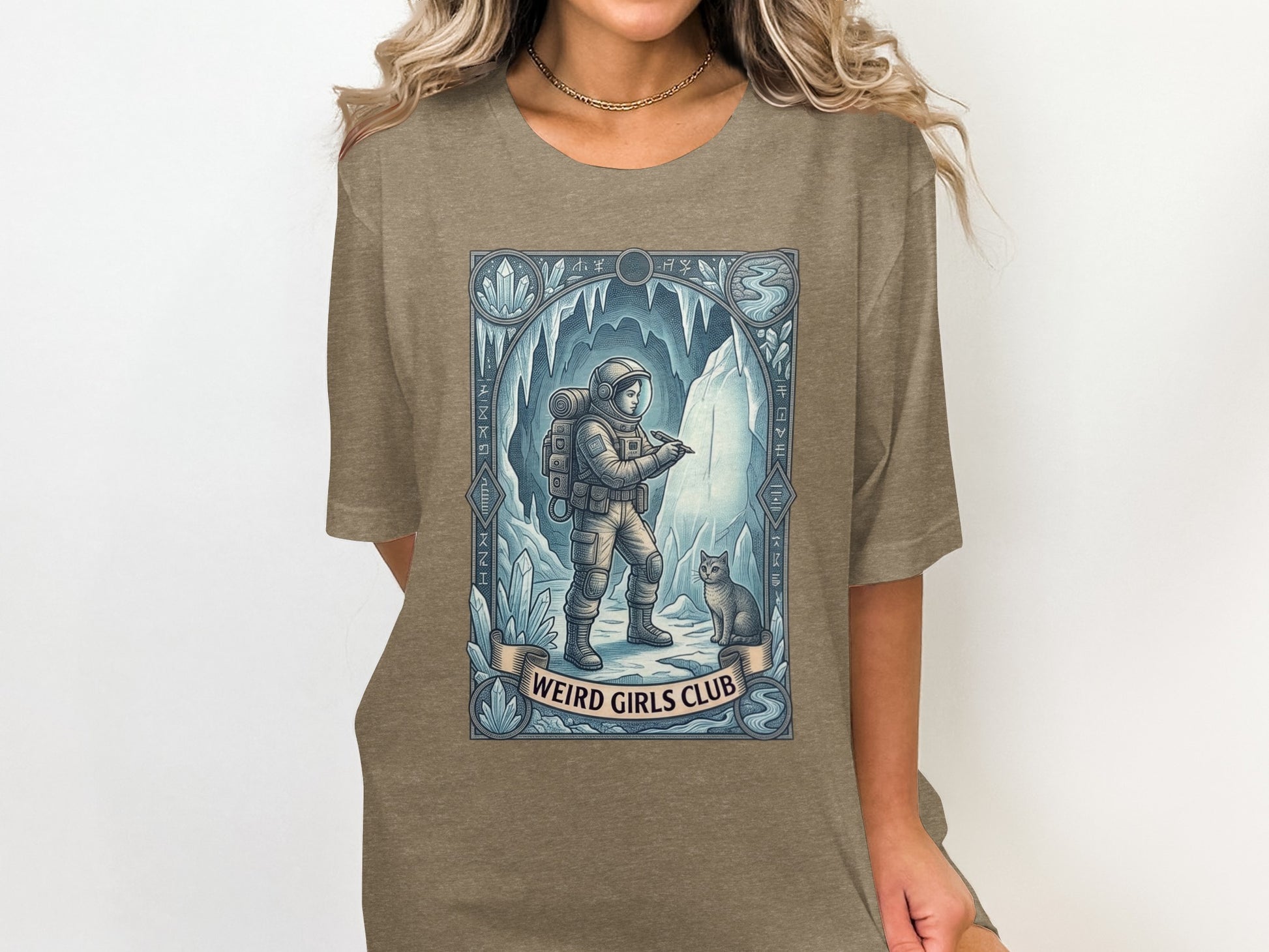 Astronaut and cat in icy cave, "Weird Girls Club" text.