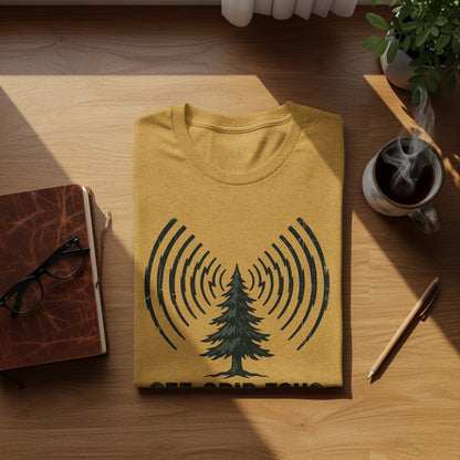 Off-Grid Radio Adventures | Vintage Outdoor Apparel: Yellow t-shirt with a pine tree and radio waves design, on a wooden surface.
