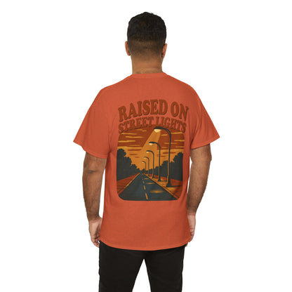 Person wearing an orange t-shirt with a graphic design and text on the back, on a white background