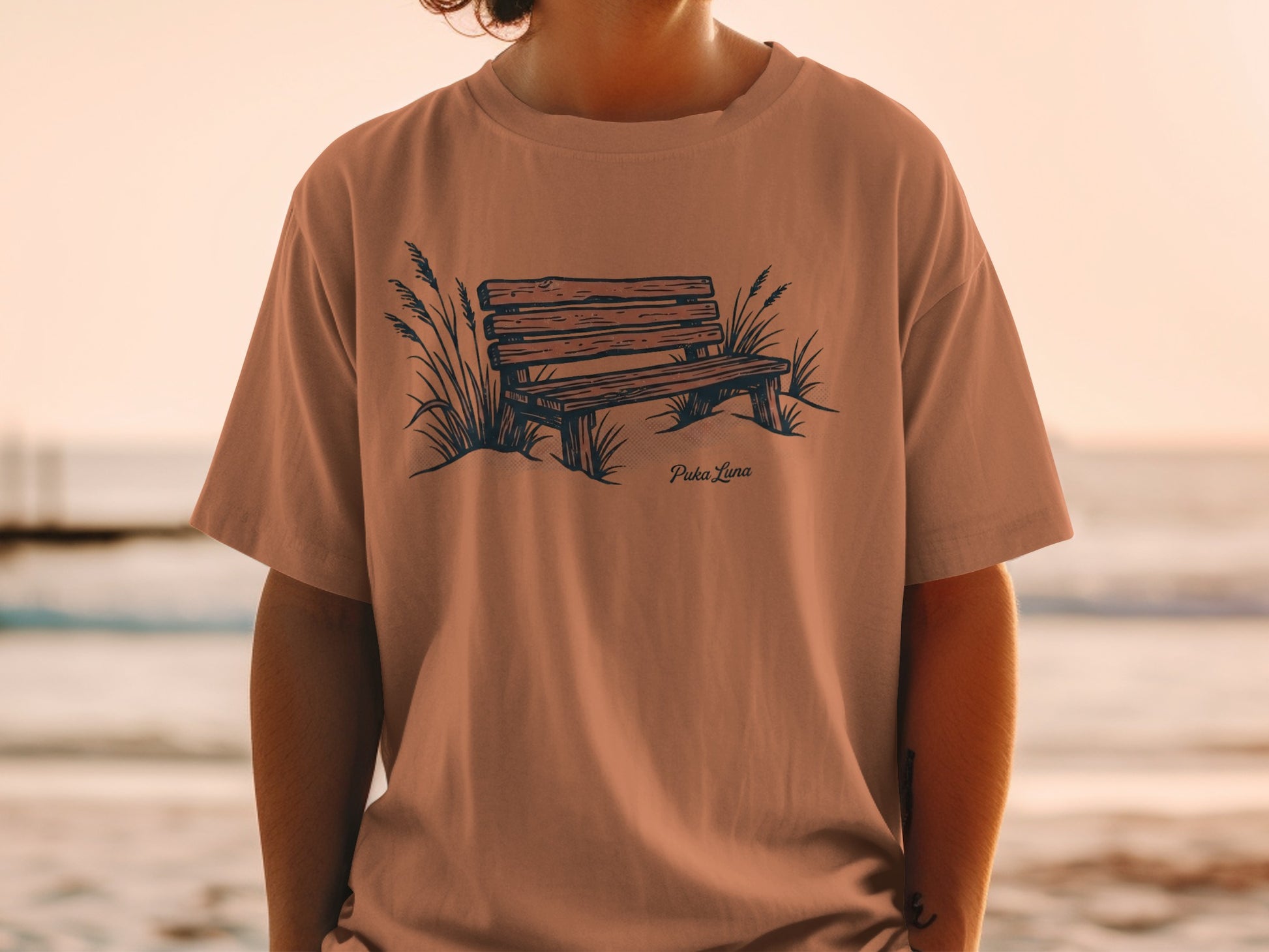 T-shirt with a drawing of a wooden bench by the sea.