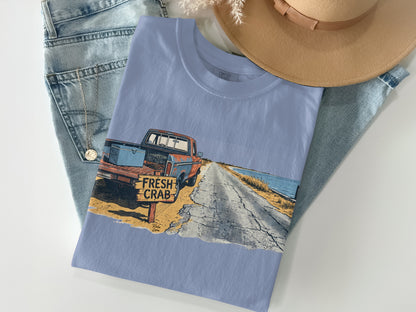Light blue t-shirt with graphic of a vintage truck on a coastal road.