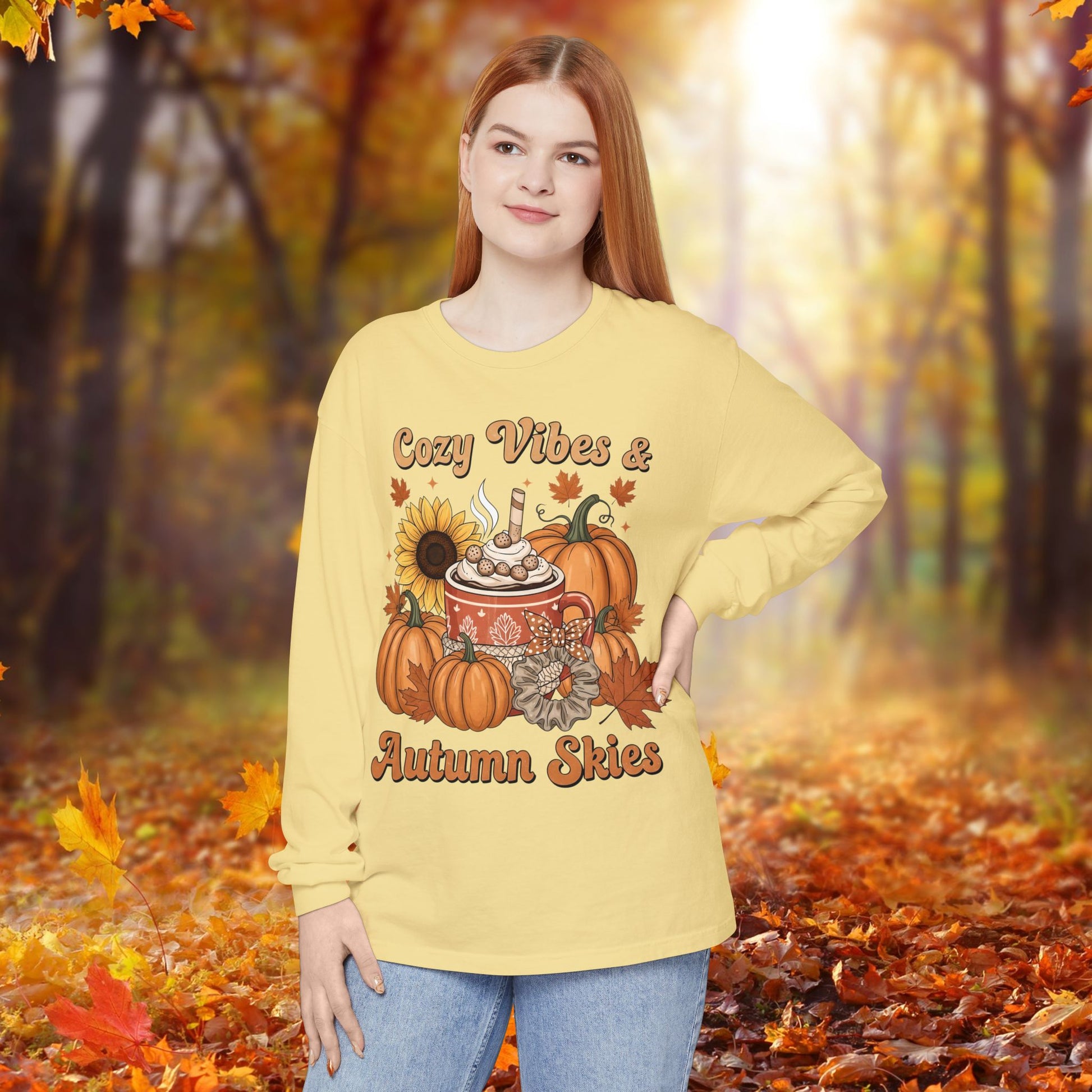 Person wearing a yellow sweatshirt with autumn-themed design in an autumn forest setting