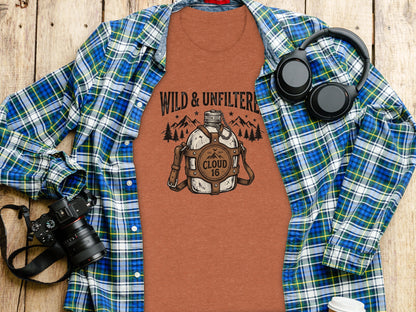 Rugged Wild & Unfiltered Spirit Wilderness Shirt: Orange t-shirt with "Wild & Unfiltered" bottle graphic and headphones.