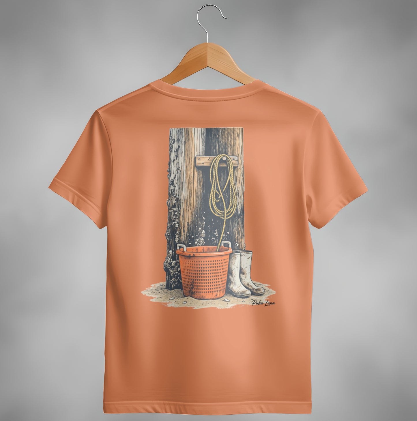 Orange t-shirt with illustration of a bucket, boots, and rope on a wooden post.