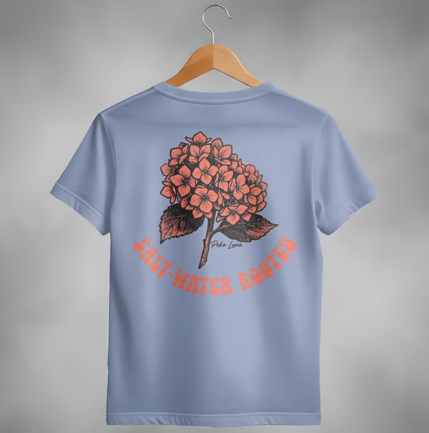 Blue t-shirt with coral hydrangea illustration and text "SALT-WATER ROOTED".