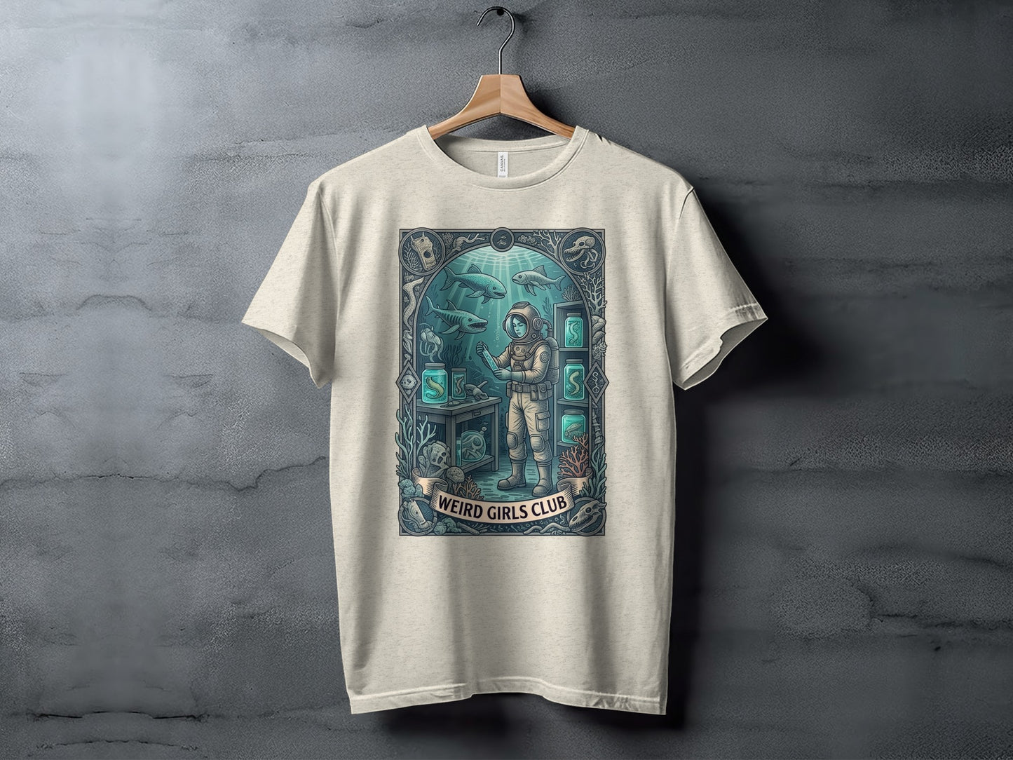 Cream t-shirt featuring a framed illustration of a diver surrounded by marine life and lab equipment.