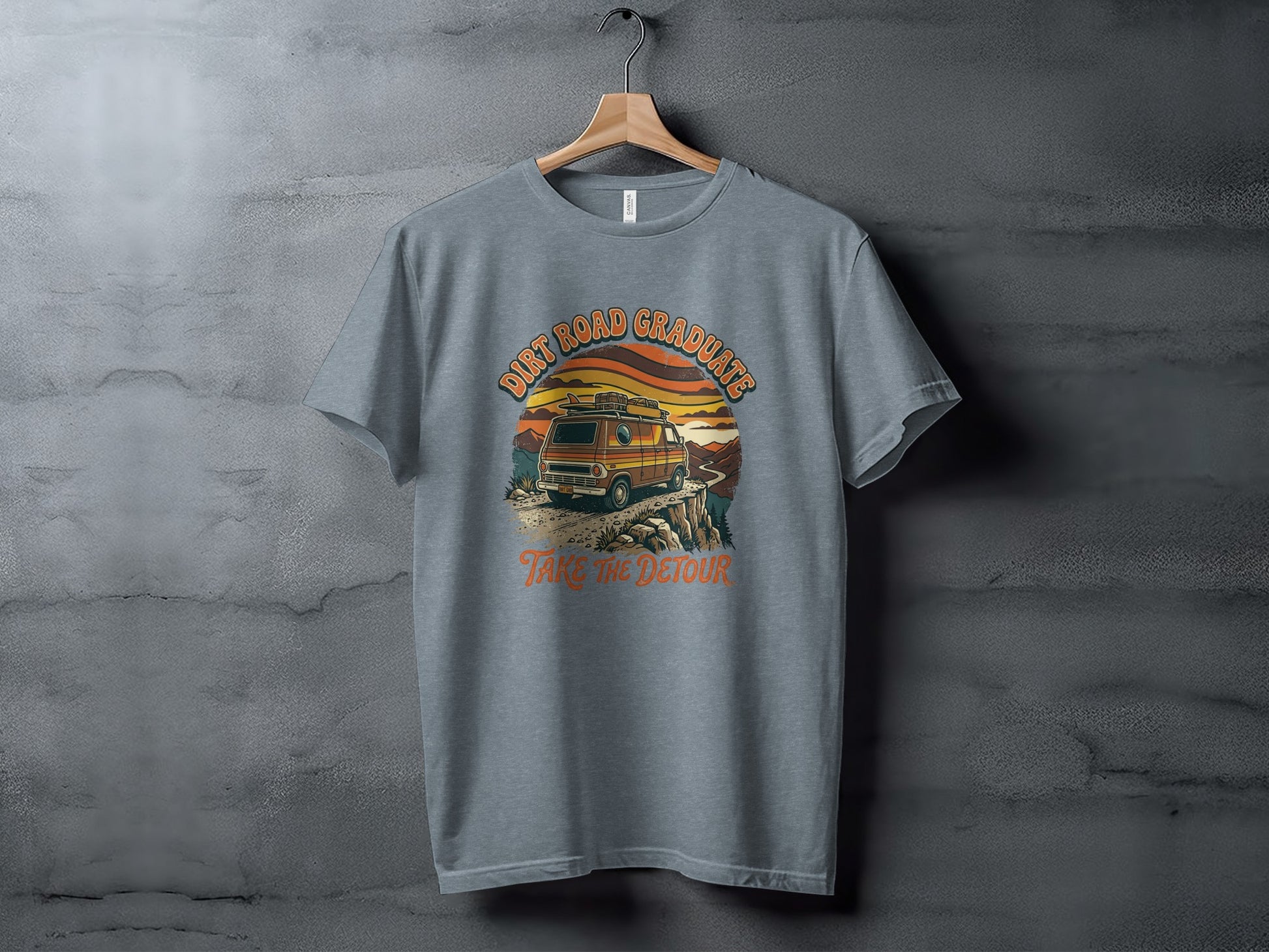 Heritage Dirt Road Graduate Adventure Tee Nomad Tee: Gray t-shirt with "Dirt Road Graduates Take The Detour" text and sunset van graphic.