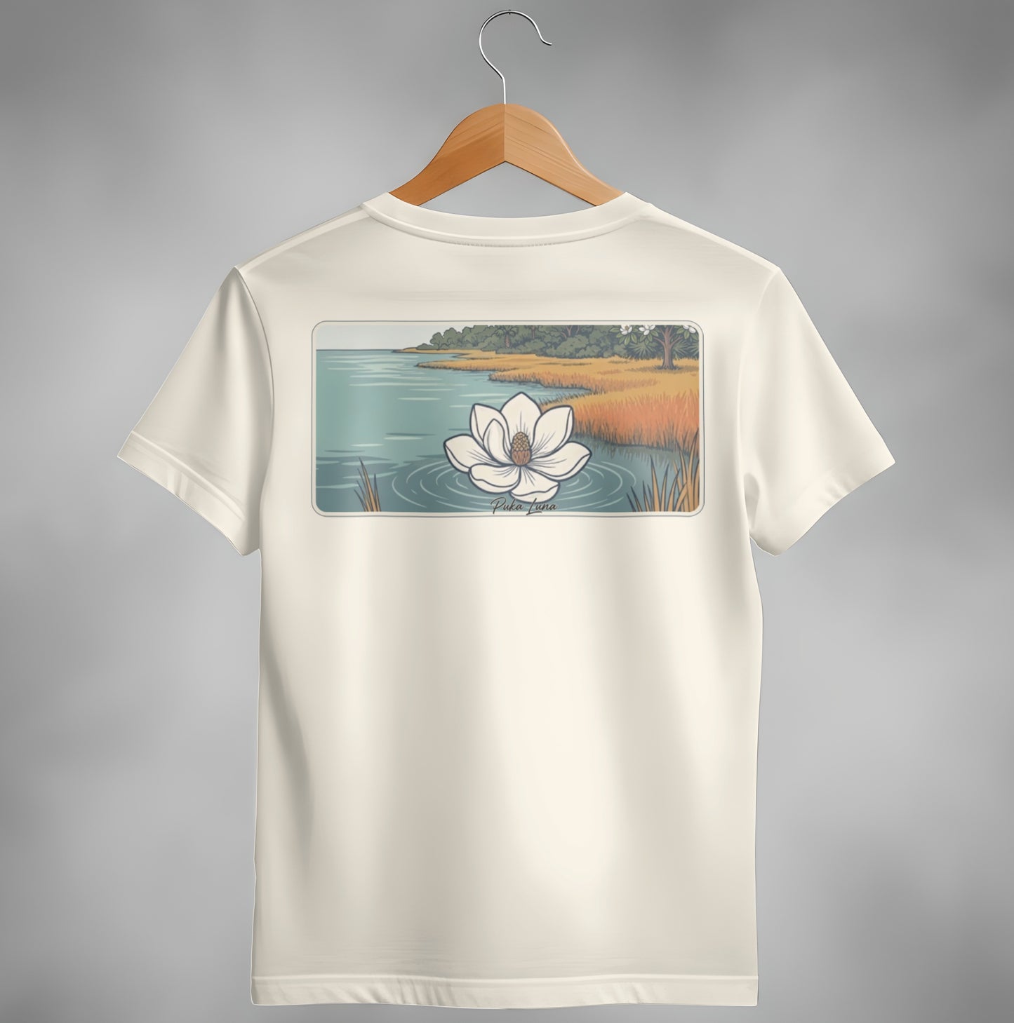 Cream t-shirt with a white magnolia flower on water and marshland scene.