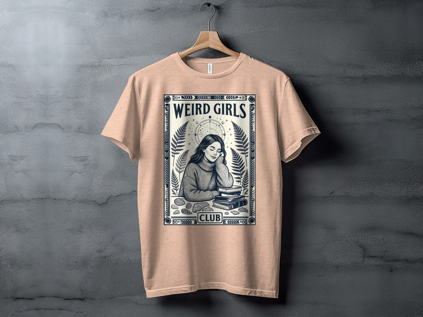 Peach t-shirt with "Weird Girls Club" text and illustration of a girl reading books.