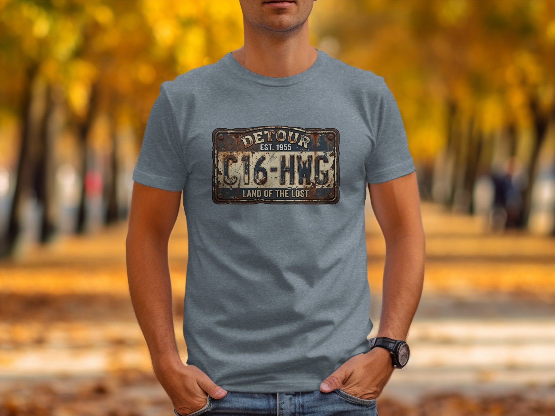 Land of the Lost Detour Plate: The Explorer's Adventure Tee: Grey t-shirt with a distressed "Detour" license plate graphic and "Land of the Lost" text.