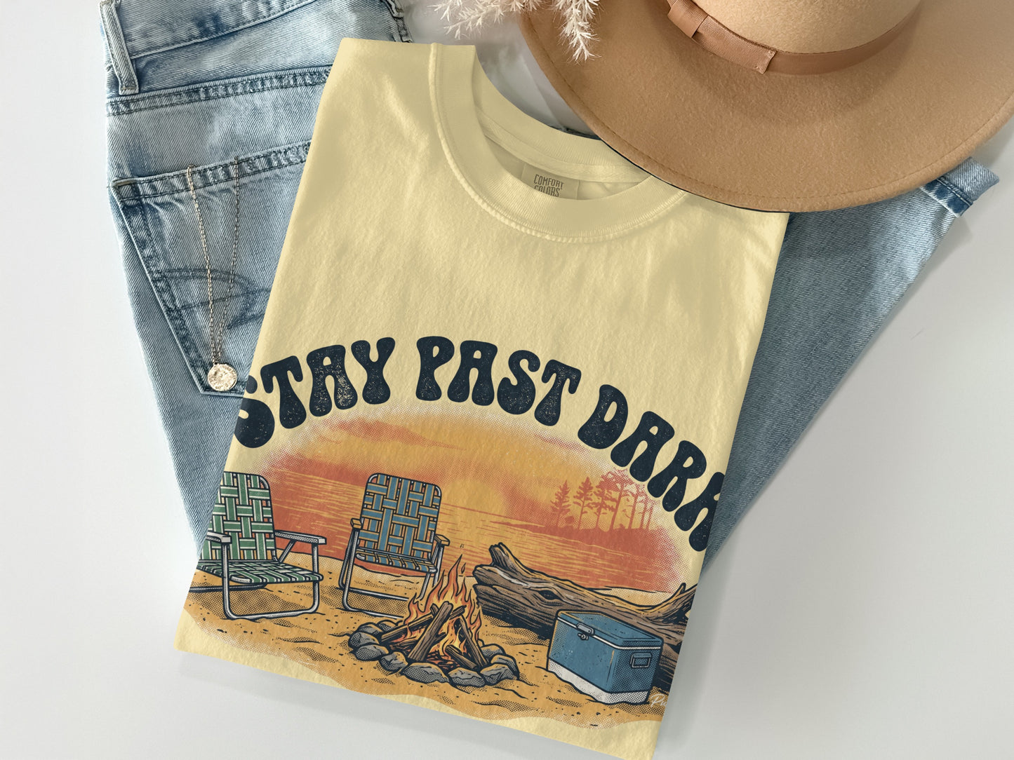 Cream t-shirt with "STAY PAST DARK" text, campfire, chairs, and cooler.