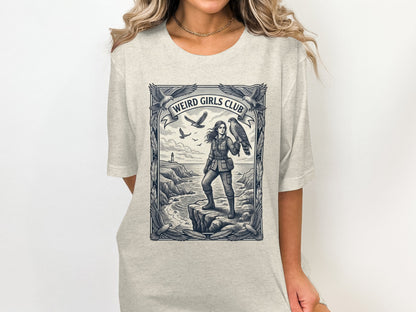 Woman in explorer outfit holding a hawk, with "Weird Girls Club" banner.