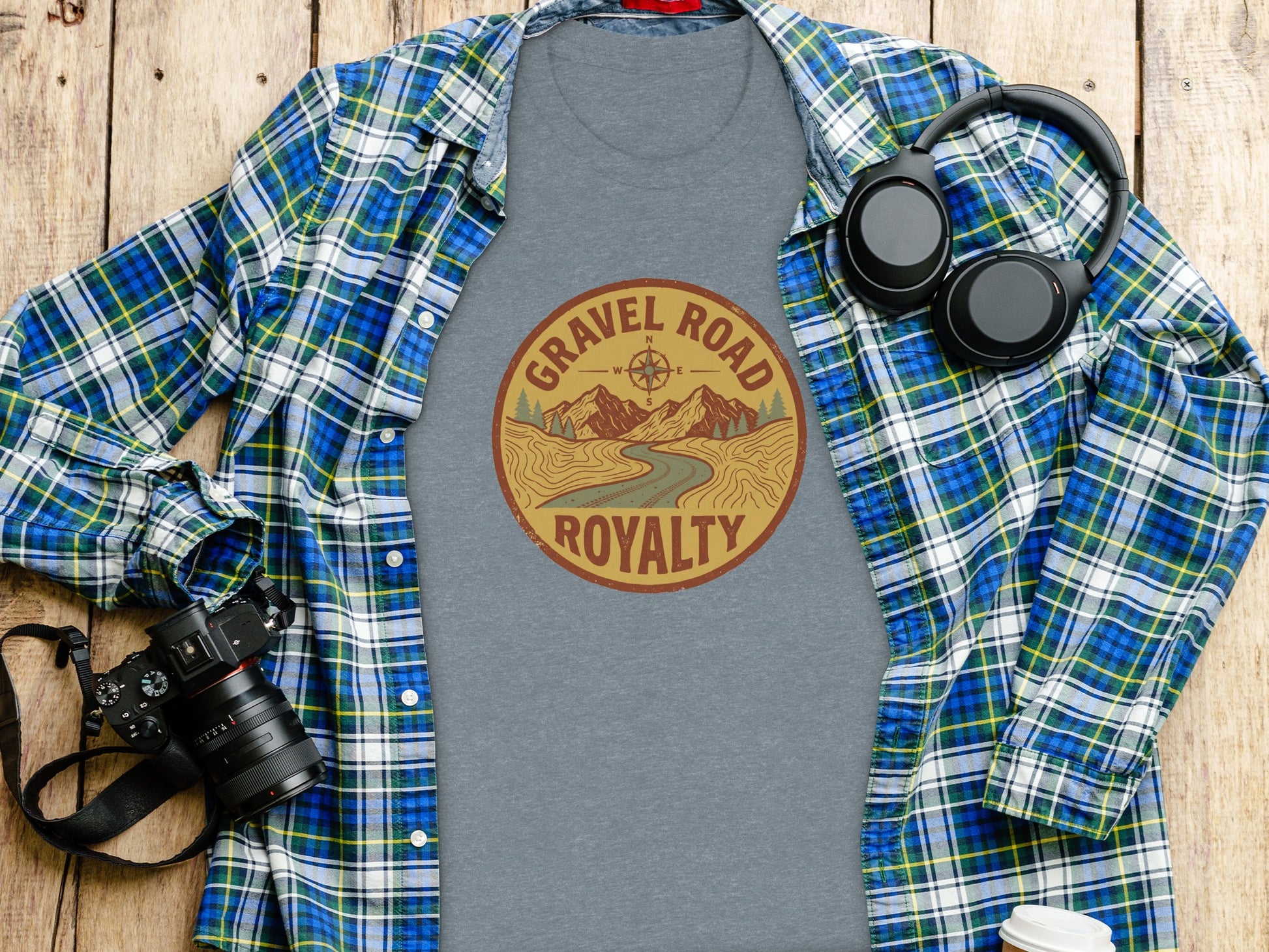 Gravel Road Royalty Adventure Tee | Vintage Outdoor Apparel: Grey t-shirt with "Gravel Road Royalty" graphic, plaid shirt, headphones, and camera.