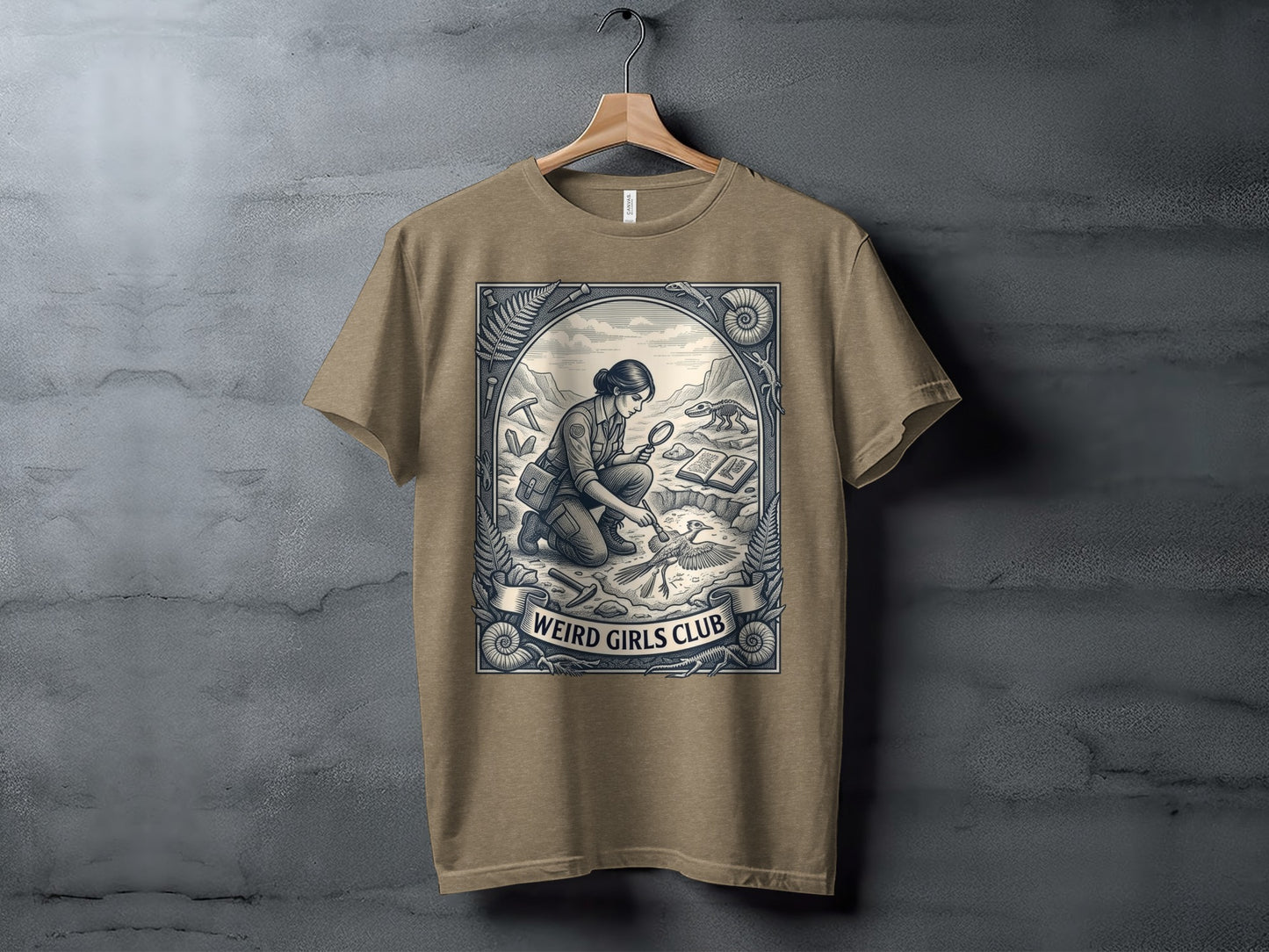 T-shirt featuring a woman examining a fossil with text "WEIRD GIRLS CLUB" banner.