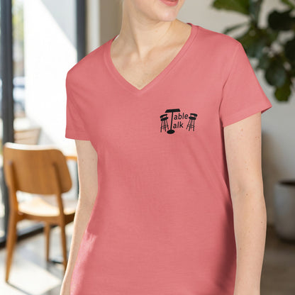 Salmon pink v-neck t-shirt with "Table Talk" logo and stools.
