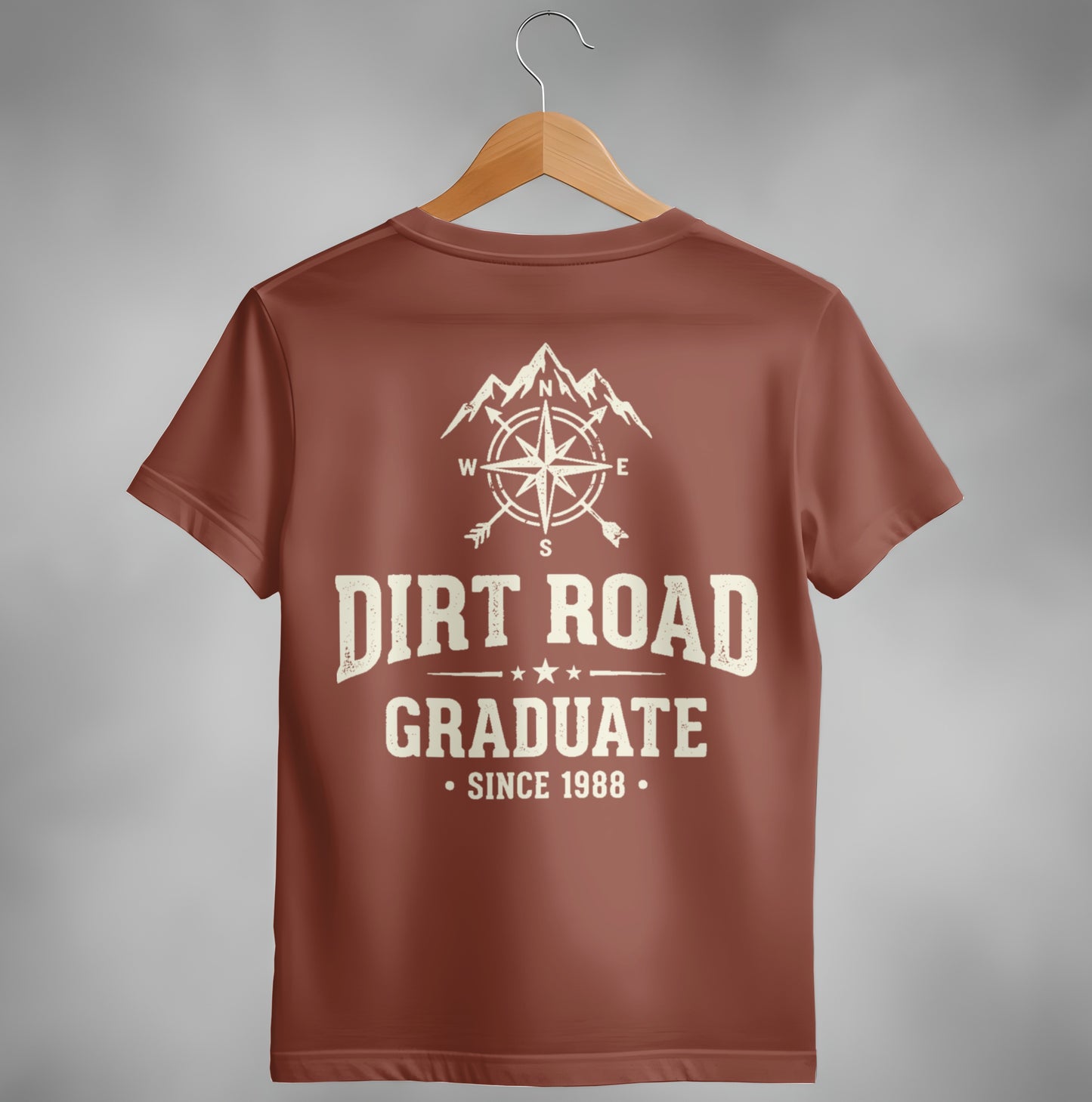 Brown t-shirt with compass, mountains, "Dirt Road Graduate Since 1988" graphic.