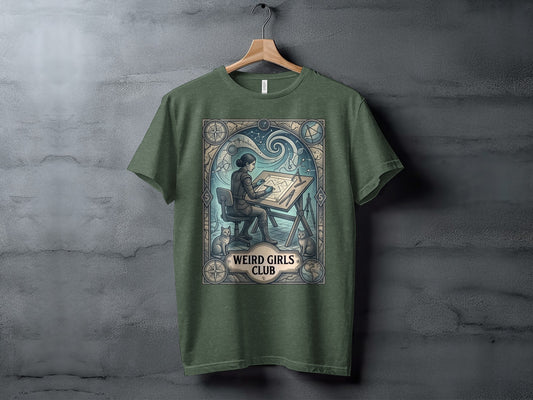 Green t-shirt with "Weird Girls Club" graphic of a woman drawing at a desk.
