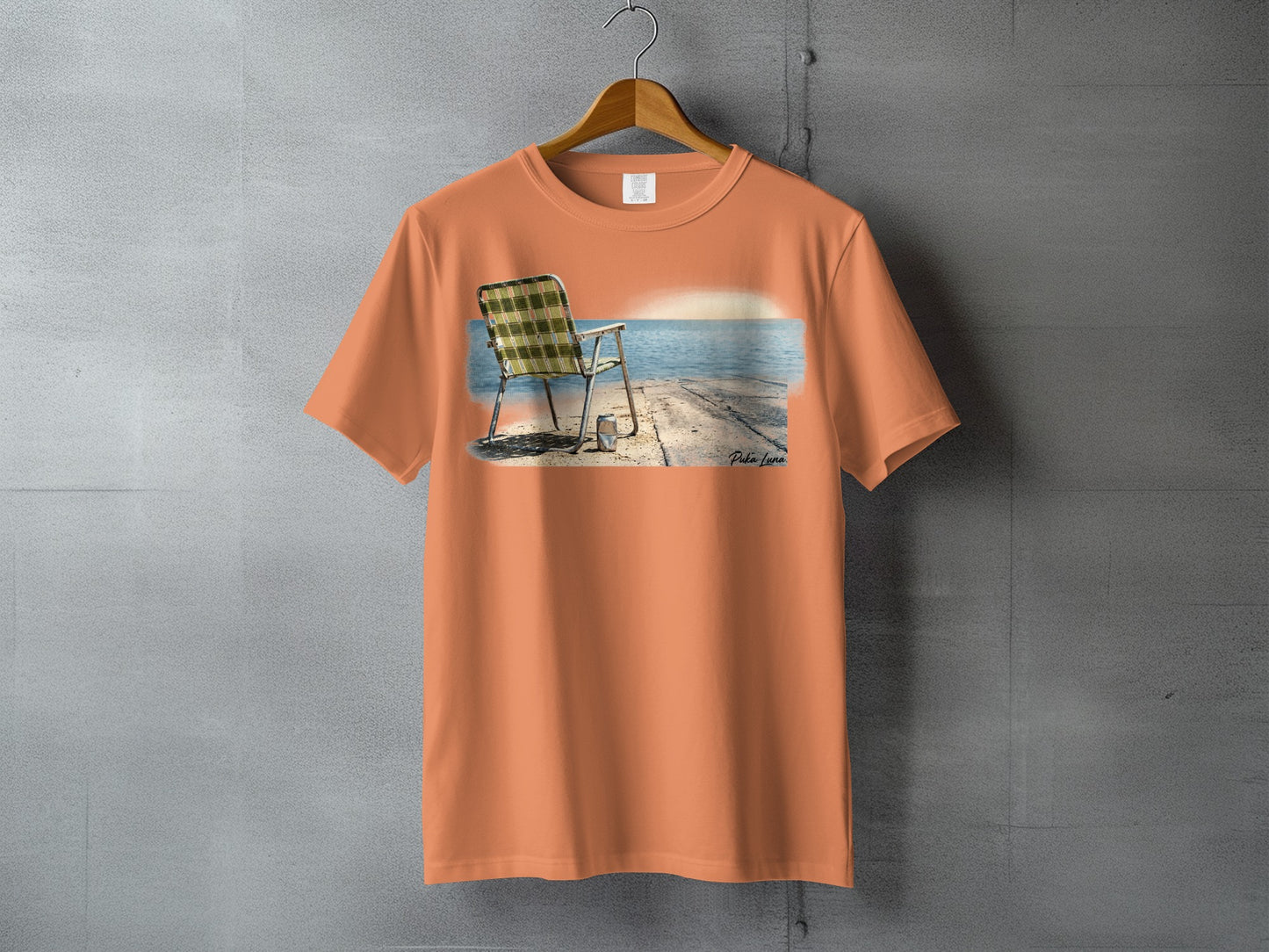 Orange t-shirt with a beach scene featuring a chair and a sunset.