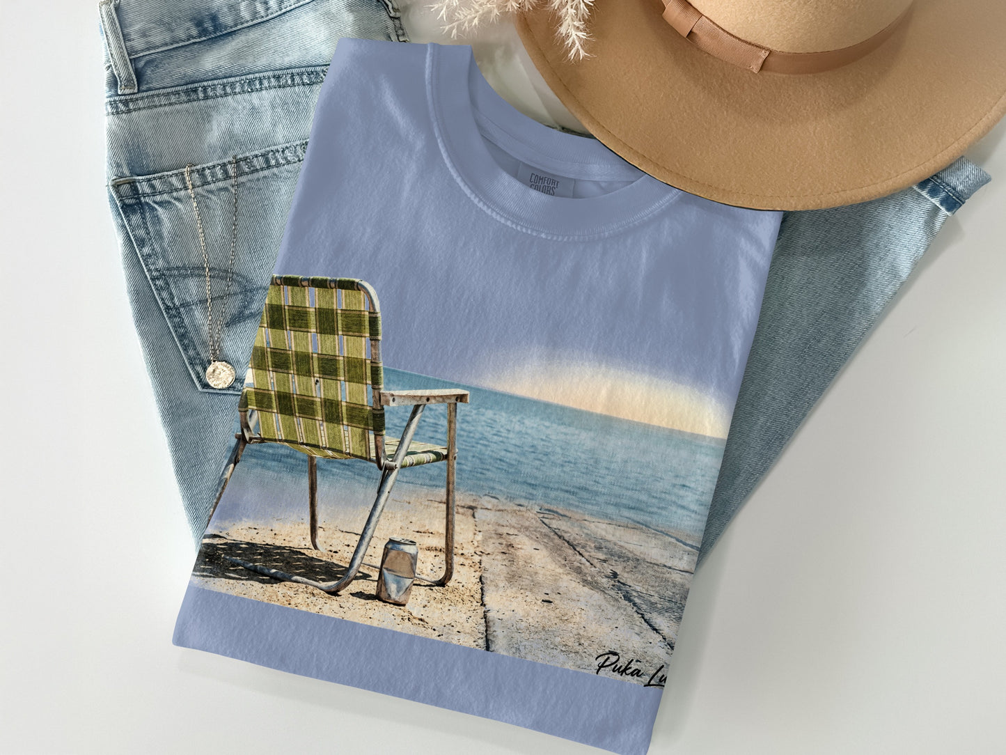 Light blue t-shirt with a beach chair and ocean graphic.