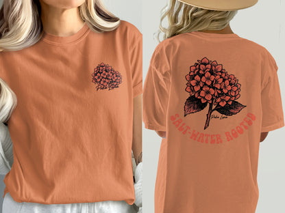 Orange t-shirt with a floral graphic and text on front and back.