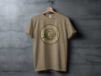 Backyard Safari Guide Explorer: Backcountry Outpost Shirt: T-shirt with "Backyard Safari Guide Hose Water Gen EST. BEFORE THE INTERNET" circular logo.