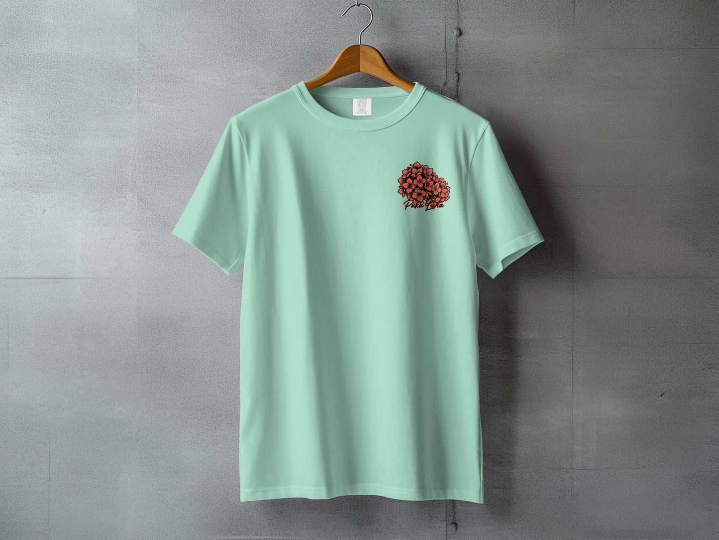 Mint green t-shirt with small red heart graphic and text on the left chest.