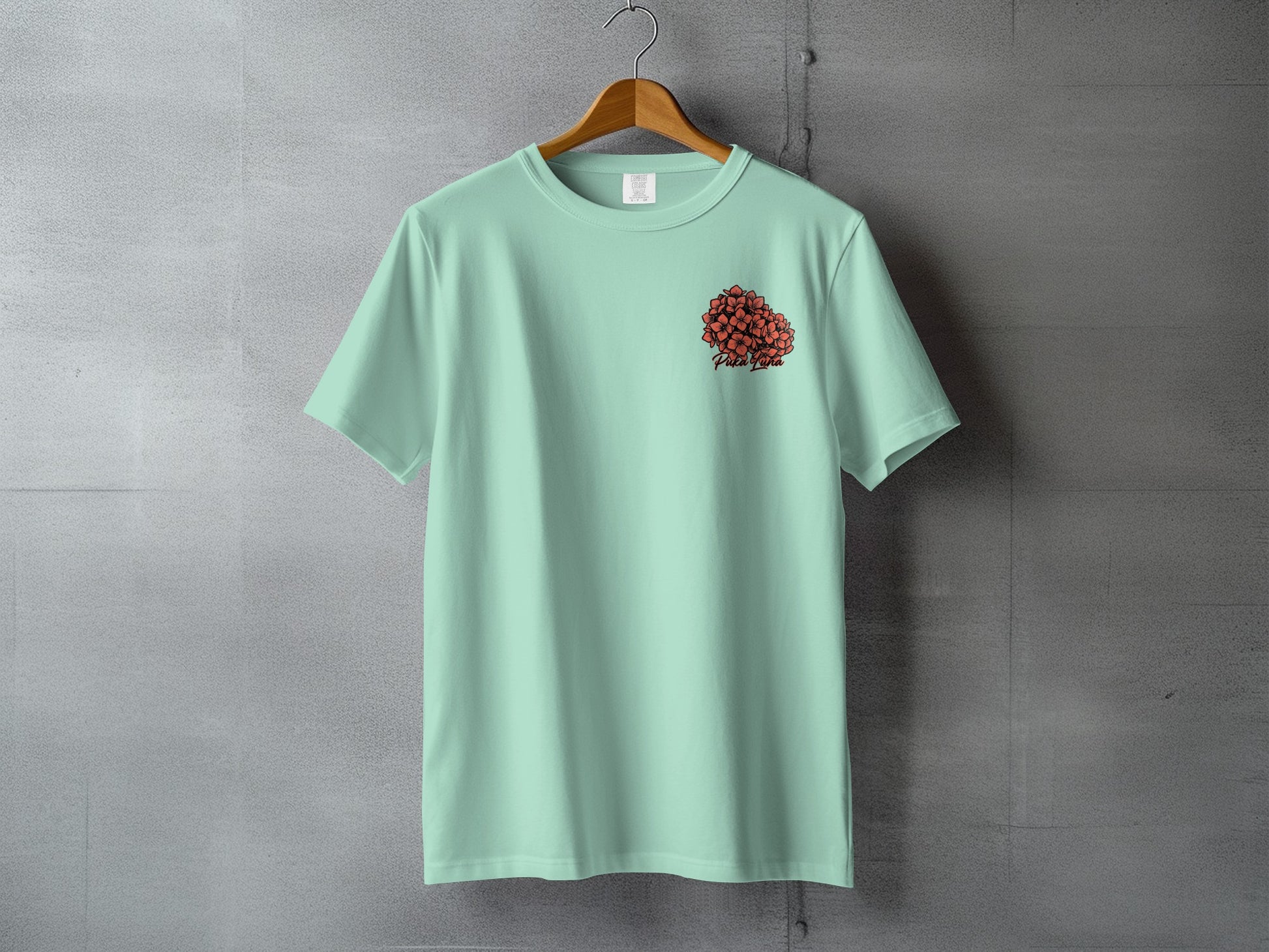 Mint green t-shirt with small red heart graphic and text on the left chest.